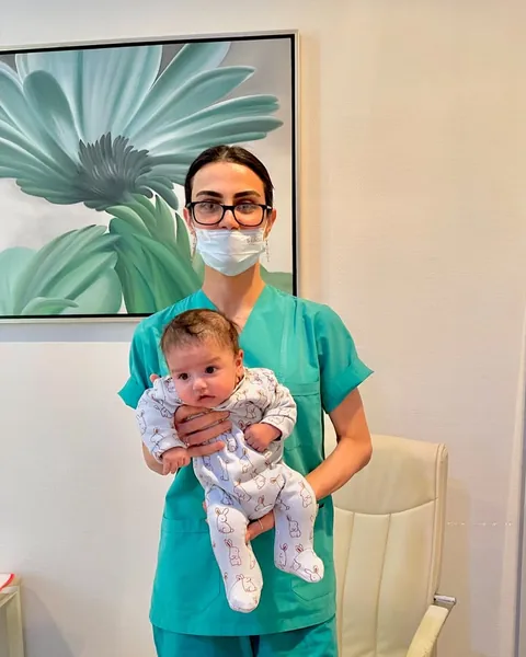 Dr. Günay Rzayeva körpəni qucağında tutur
