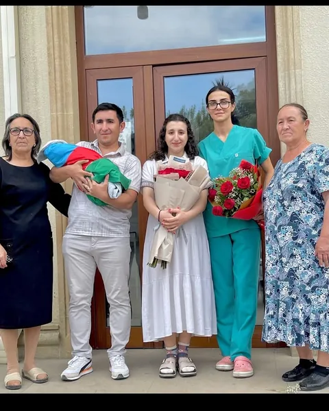 Ailə üzvləri körpə ilə, yanlarında həkim