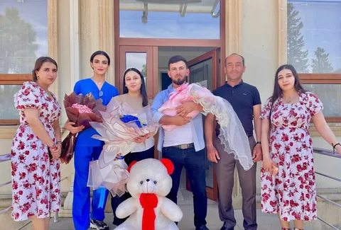 Ailə yeni doğulmuş körpə ilə xəstəxananın qarşısında