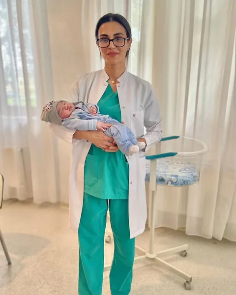 Dr. Günay Rzayeva körpəni qucağında tutaraq