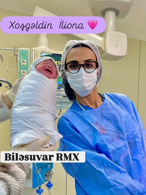 Dr. Günay Rzayeva yaşıl cərrahi xalatda yeni doğulmuş körpə ilə