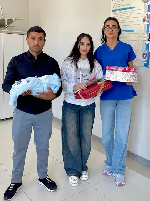 Valideynlər körpə ilə, yanlarında həkim